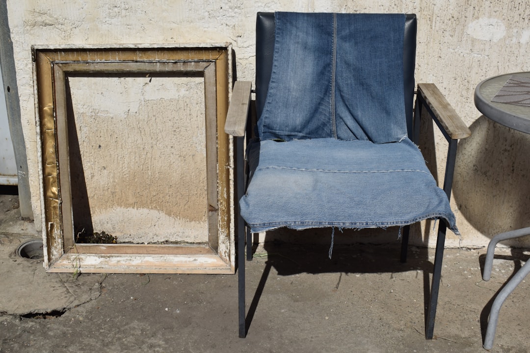 Chair with denim seat next to empty frame