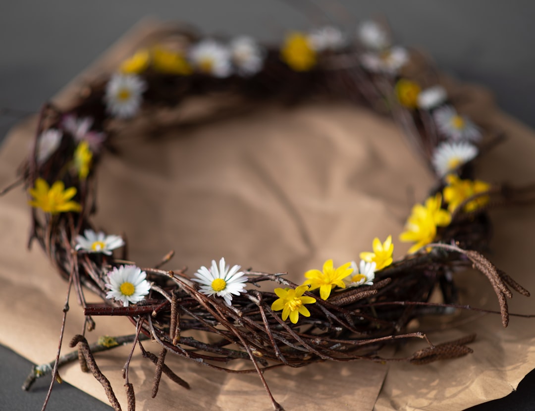A rustic wreath adorned with daisies and yellow flowers